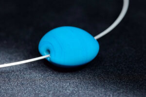 Große handgefertigte Lampwork-Linsenperle in Türkis als Wechselperle auf einem Edelstahl-Halsreif Große handgefertigte Lampwork-Linsenperle in Türkis als Wechselperle auf einem Edelstahl-Halsreif.